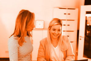 Foto von zwei Personen vor einem Laptop